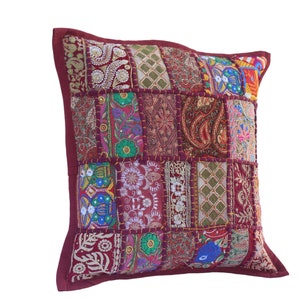 Könnte beinhalten: Ein burgunderfarbener Patchwork-Kissenbezug mit bunten Stickereien und einem Paisley-Muster. Der Kissenbezug besteht aus verschiedenen Stoffen und ist mit aufwendigen Nähten verziert.