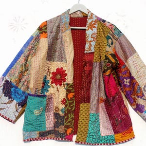 May include: A colorful patchwork jacket with a red lining. The jacket is made of different fabrics and has a variety of patterns, including floral, paisley, and geometric designs.