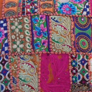 Puede incluir: Una funda de coj&iacute;n de patchwork colorido con bordados intrincados y lentejuelas. La funda est&aacute; hecha de varias telas en tonos naranja, rosa, azul, verde y blanco. La funda de coj&iacute;n es perfecta para agregar un toque de estilo bohemio a cualquier habitaci&oacute;n.