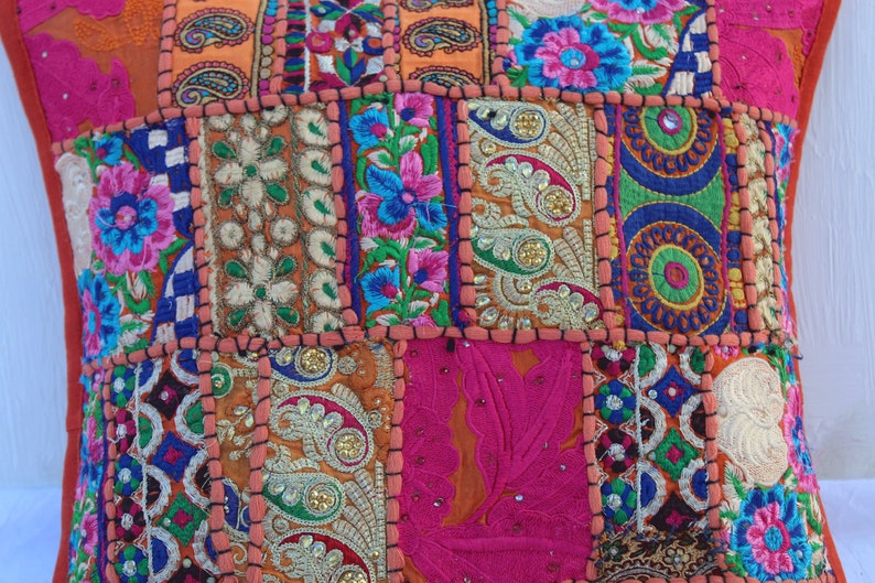 Puede incluir: Una funda de coj&iacute;n de patchwork colorido con bordados intrincados y lentejuelas. La funda est&aacute; hecha de varias telas en tonos naranja, rosa, azul, verde y blanco. La funda de coj&iacute;n es perfecta para agregar un toque de estilo bohemio a cualquier habitaci&oacute;n.
