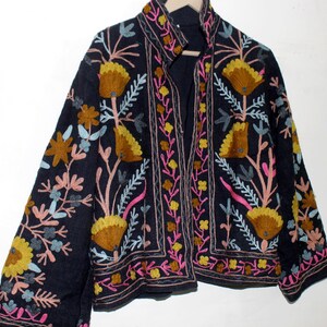 Pu&ograve; includere: Giacca blu navy scuro con ricami floreali colorati. La giacca presenta un design dettagliato con fiori e foglie gialle, rosa e blu. Il ricamo &egrave; sulla parte anteriore, sulle maniche e sul colletto.