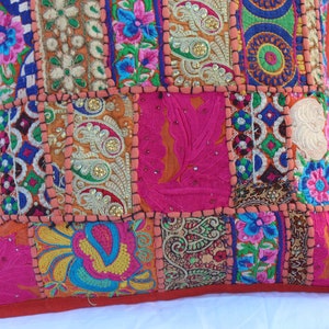 Puede incluir: Una funda de coj&iacute;n de patchwork colorido con bordados y lentejuelas intrincados. La funda est&aacute; hecha de varias telas en tonos de rosa, naranja, azul, verde y dorado. La funda de coj&iacute;n es perfecta para agregar un toque de estilo bohemio a cualquier habitaci&oacute;n.