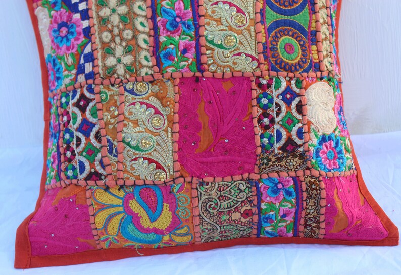 Puede incluir: Una funda de coj&iacute;n de patchwork colorido con bordados y lentejuelas intrincados. La funda est&aacute; hecha de varias telas en tonos de rosa, naranja, azul, verde y dorado. La funda de coj&iacute;n es perfecta para agregar un toque de estilo bohemio a cualquier habitaci&oacute;n.