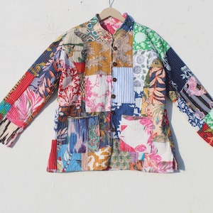 Könnte beinhalten: Eine bunte Patchworkjacke mit Knopfleiste und langen Ärmeln. Die Jacke besteht aus verschiedenen Stoffen in den Farben Blau, Rot, Grün und Weiß.