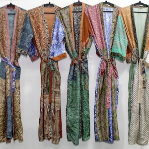 May include: Five colorful silk robes with different patterns hang on hangers against a white background. The robes are made of patchwork fabric and have long sleeves and a sash.