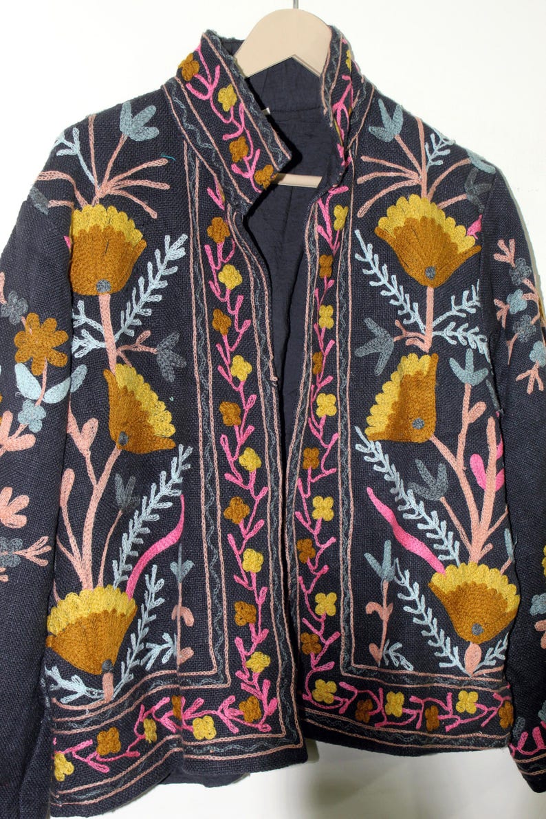 Pu&ograve; includere: Giacca blu navy scuro con ricami floreali colorati. La giacca presenta grandi fiori stilizzati in tonalit&agrave; oro e giallo, con accenti rosa, blu e verdi. Il ricamo &egrave; dettagliato e copre la parte anteriore, il colletto e le maniche.