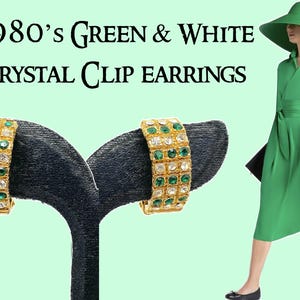 May include: A pair of gold tone clip-on earrings with green and clear crystal stones. The earrings are on a black display stand. 1980's Green & White Crystal Clip Earrings