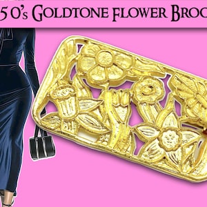 Puede incluir: Un broche de flores de tono dorado con un diseño delicado e intrincado. El broche presenta un grupo de flores estilizadas con pétalos abiertos y tallos.