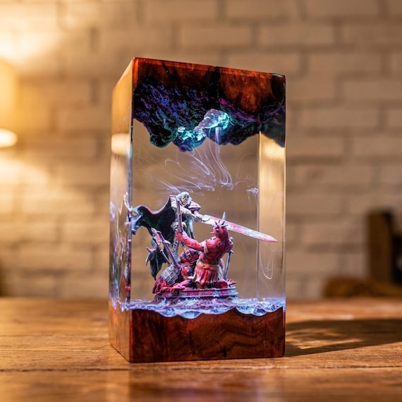 A hand-poured epoxy resin lamp encasing a fully sculpted fantasy warrior diorama — it glows from within like a scene frozen in another world.