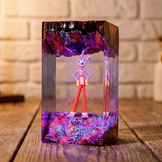 A handmade epoxy resin lamp with a whimsical bunny figure encased in glowing wood — the kind of moody desk accent that looks like it escaped a fantasy novel.