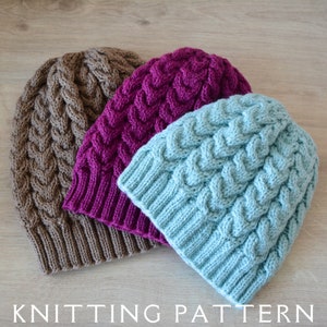 May include: Three knitted hats in brown, purple, and light blue with a cable knit pattern.  KNITTING PATTERN.