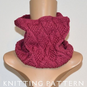 May include: A burgundy knitted cowl neck scarf with a textured pattern.