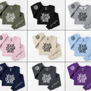 Op de afbeelding: Negen verschillende sweatshirts in verschillende kleuren met de tekst "YOUR DESIGN HERE" op de voorkant. De sweatshirts zijn dubbelgevouwen en liggen op een witte achtergrond.
