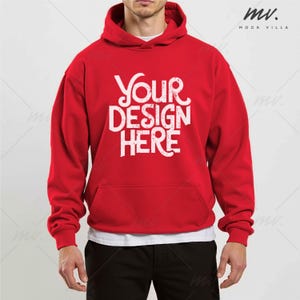 May include: A red hoodie with a white "Your Design Here" graphic. The hoodie has a front pocket and a drawstring hood. The model is wearing a white t-shirt underneath and black pants.
