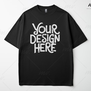 May include: Black t-shirt with short sleeves and a crew neck. The shirt has the text "YOUR DESIGN HERE" printed on the front in a white distressed font.