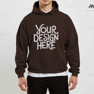 May include: A brown hooded sweatshirt with the text "YOUR DESIGN HERE" printed on the front.
