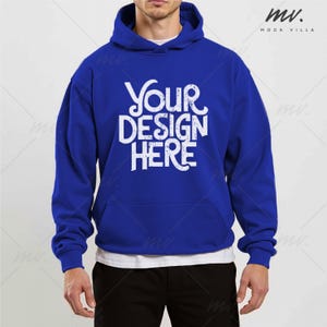 May include: A royal blue hoodie with a white graphic that reads "Your Design Here." The hoodie has a front pocket and a drawstring hood. The model is wearing a white undershirt. The hoodie is a mock-up for custom designs.