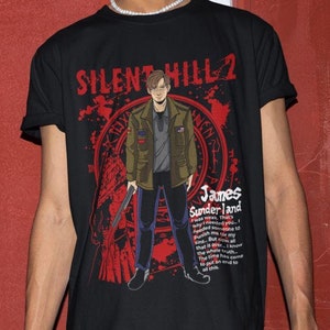 May include: Black t-shirt featuring a graphic print of a man holding a weapon. The graphic includes the text "SILENT HILL 2" and a quote from the game.