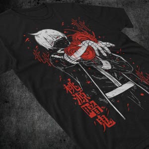 Könnte beinhalten: Schwarzes T-Shirt mit einer Grafik eines Anime-Charakters mit weißen Haaren, einer schwarzen Maske und einem roten herzförmigen Design. Roter japanischer Text ist vertikal auf das Shirt gedruckt.