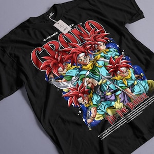 May include: Black t-shirt with a graphic of a character with red hair and a blue and green outfit. The word "CHRONO" is in red, and the text "THE TIME TRAVELER" is also visible. A size tag is attached.