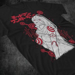 Peut inclure: T-shirt noir avec une illustration de style anime en blanc et rouge. Le design présente une figure féminine aux longs cheveux blancs et des accents rouges, ainsi que du texte japonais. Graphisme saisissant.