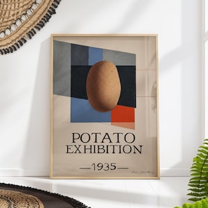 Puede incluir: Lámina enmarcada que presenta una patata marrón sobre un fondo geométrico de formas azules, negras, grises y rojas. El texto "POTATO EXHIBITION - 1935" se muestra en negro. La obra de arte está en un marco de madera.