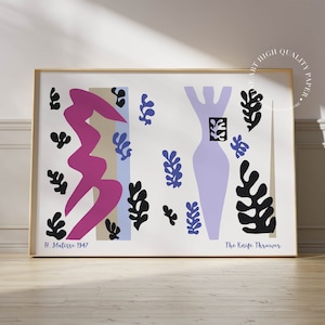 Può includere: Una stampa incorniciata di un dipinto di Matisse che presenta una figura viola con forme di foglie nere e blu. Il testo "The Knife Thrower" è in basso sulla stampa.