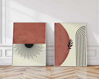 Könnte beinhalten: Zwei gerahmte abstrakte Kunstdrucke. Einer zeigt einen rostfarbenen oberen Bereich, ein schwarzes Sonnenstrahl-Design und einen cremefarbenen unteren Bereich. Der andere hat eine rostfarbene Form, ein schwarzes Blatt und einen cremefarbenen Hintergrund mit schwarzen Bögen und roten Punkten.
