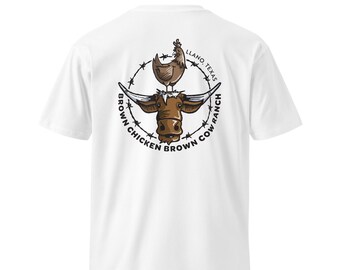 Puede incluir: Camiseta blanca con un diseño gráfico circular que muestra una vaca marrón, una gallina y el texto "Brown Chicken Brown Cow Ranch, Llano, Texas". El diseño está enmarcado por un borde similar al alambre de púas. La camiseta es de material suave y cómodo.