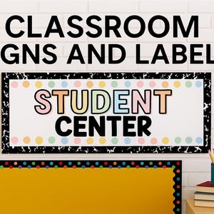 May include: Classroom signs and labels are displayed on a white brick wall. The top sign reads "STUDENT CENTER" in colorful letters. Below is a yellow bulletin board with a black border. A small blue cup holds pencils, and books are stacked on a wooden surface.