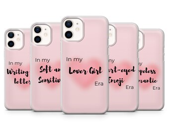 Pode incluir: Um conjunto de capas de telefone rosa com frases e um coração. As frases incluem "Writing letter", "Soft and Sensitiv", "Lover Girl", "Heart-eyed Emoji" e "Hopeless romantic". Cada capa tem a palavra "Era".