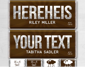 May include: Two brown chocolate bar wrappers with silver glitter text. The top wrapper says "HEREHEIS RILEY MILLER" and the bottom wrapper says "YOUR TEXT TABITHA SADLER".  The wrappers are for a baby shower and have a brown and silver glitter design.