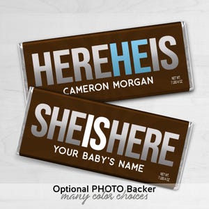 May include: Two chocolate bars with silver foil wrapping. The top bar reads "HEREHEIS" with "CAMERON MORGAN" below. The bottom bar says "SHEISHERE" with "YOUR BABY'S NAME" below. Each bar is labeled "NET WT. 3.3 kg".