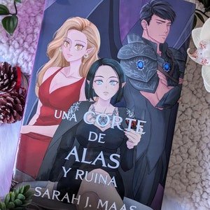 Puede incluir: Una portada de libro con fondo morado y tres personajes. Los personajes son una mujer con el pelo largo y rubio, una mujer con el pelo corto y negro y un hombre con el pelo negro. El título del libro es "Una Corte de Alas y Ruina" de Sarah J. Maas.
