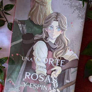 Op de afbeelding: Een boekomslag met een fantasievolle illustratie van twee mensen met lang haar. De titel van het boek is "Een Hof van Doornen en Rozen" door Sarah J. Maas.