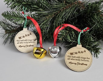 May include: Three wooden Christmas ornaments with red and green ribbon. Each ornament features a bell with the word "Believe" engraved on it. The ornaments also have the text "The bell still rings for all who truly believe. Merry Christmas" engraved on them.