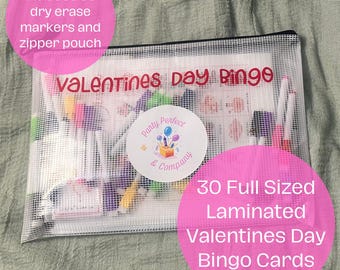 May include: A clear zippered pouch containing Valentine's Day Bingo cards, dry erase markers, and a zipper pouch. The text "Valentines Day Bingo" is visible. The set includes 30 full-sized laminated bingo cards.