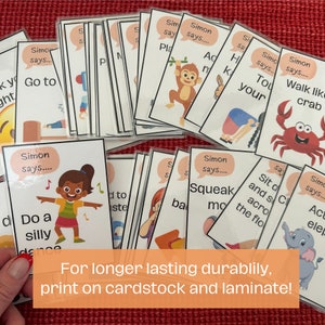 Op de afbeelding: Een verzameling gelamineerde activiteitskaarten met illustraties en de tekst "Simon says...". De kaarten tonen verschillende acties zoals "Do a silly dance" en "Walk like a crab". De afbeelding bevat ook de tekst "For longer lasting durabilily, print on cardstock and laminate!"