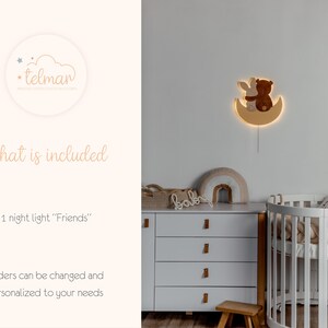 May include: A wooden night light shaped like a crescent moon with a brown bear and a bunny sitting on it. The night light is lit up and casts a warm glow. The text "Friends" is written on the product description.