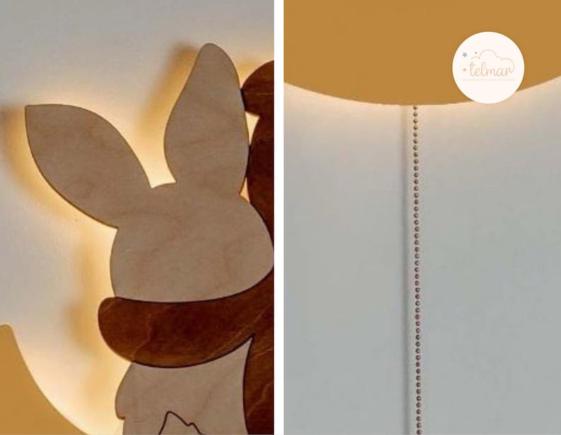 May include: A wooden night light shaped like a bunny and a bear hugging each other. The light is illuminated and casts a warm glow. The night light is mounted on a white wall.