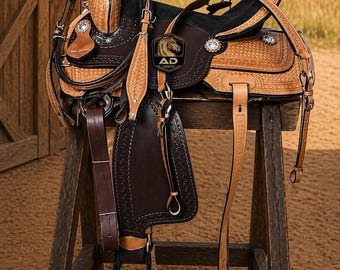 May include: A detailed western saddle, displayed on a wooden stand. The saddle features intricate tooling, a dark brown seat, and lighter brown leather accents. The image includes the text "AD" with a horse head logo.