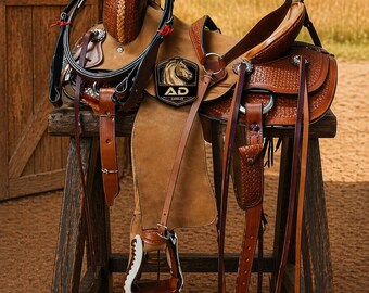 May include: A brown leather saddle with intricate tooling and a suede seat, displayed on a wooden stool. The saddle features stirrups, reins, and a headstall. The logo "AD Saddler" is visible on the saddle. The background shows a wooden door and a field.