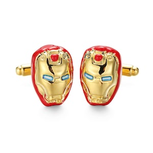 Könnte beinhalten: Ein Paar goldene Manschettenknöpfe mit roten und goldenen Iron Man-Masken.