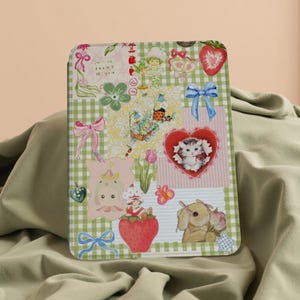 May include: A green and white gingham background with a patchwork of colourful images. The images include a strawberry, a cat, a bunny, a ladybug, a flower, and a heart. The text "I am so proud of you" is visible in the top left corner.