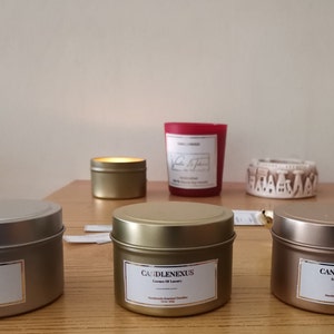 Scented Soy Candles in various tins. Luxury gold foil labels as well among with wood wick