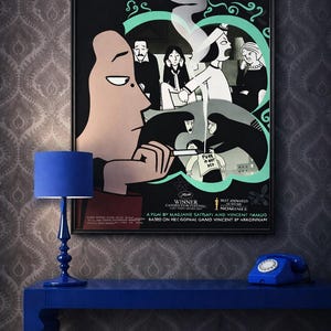 May include: A framed movie poster for "Persepolis" hangs above a blue table with a blue lamp and a blue rotary phone. The poster features a black and white illustration with the film's title and credits.