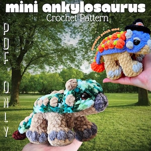 May include: Two crocheted ankylosaurus dinosaurs. One is green, blue, and tan, and the other is blue, orange, and tan, wearing a black hat. The image includes the text "mini ankylosaurus Crochet Pattern".