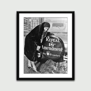 May include: A woman in a fur coat stands next to a car tire with a sign that reads "Repeal the 18th Amendment The Crusaders".