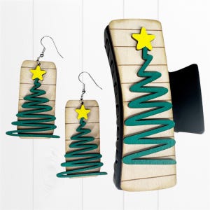 May include: Wooden Christmas tree earrings and a hair clip. The earrings and clip feature a light wood grain background with a green zig-zag tree design and a yellow star on top. The earrings have silver hooks.