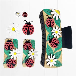 May include: Wooden hair claw clip and matching accessories featuring a ladybug and daisy theme. The clip and accessories are painted with red, black, white, yellow, and green details. The clip is approximately 4 inches long.